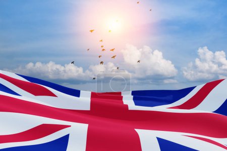 Téléchargez les photos : Drapeaux nationaux du Royaume-Uni avec des oiseaux volants sur fond bleu ciel. Contexte avec place pour votre texte. Rendu 3d. - en image libre de droit