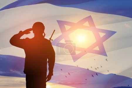 Soldatensilhouette beim Salut gegen den Sonnenaufgang in der Wüste und Israel-Flagge. Konzept - Streitkräfte Israels. Nahaufnahme.