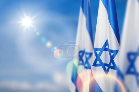 Israel-Fahnen mit einem Davidstern über bewölktem Himmel. Patriotisches Konzept über Israel mit Nationalstaatsymbolen. Banner mit Platz für Text.