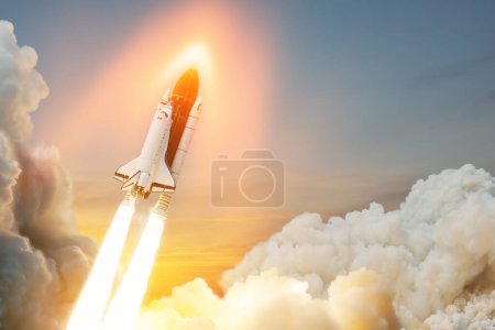 Spaceship lift off. Space shuttle with smoke and blast takes off into space on a background of sunset. Successful start of a space mission. Travel to Mars. Elements of this image furnished by NASA.