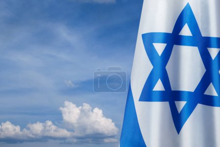 Foto de Bandera de Israel con una estrella de David sobre el fondo nublado del cielo. Concepto patriótico sobre Israel con símbolos estatales nacionales. Banner con lugar para texto. - Imagen libre de derechos