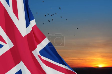 Téléchargez les photos : National flags of United Kingdom with flying birds on sunset sky background. Background with place for your text. 3d rendering. - en image libre de droit
