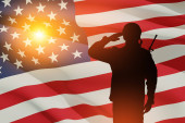 USA army soldier saluting on a background of sunset or sunrise and USA flag. Greeting card for Veterans Day, Memorial Day, Independence Day. America celebration. Closeup. 3D-rendering. Poster #644914418