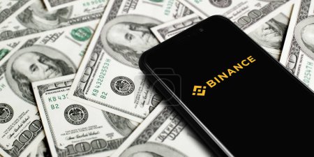 Photo for Smartphone with Binance logo on background of dollars. Binance is a cryptocurrency exchange. Moscow, Russia - November 1, 2022. - Royalty Free Image