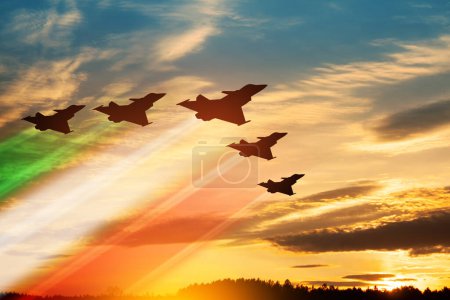 Silhouettes d'avions avec des traînées de couleurs drapeau sur fond de coucher de soleil. Journée de l'Air Force. 28 mars, Armée de l'air italienne.
