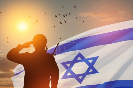 Silueta de soldados saludando contra el amanecer en el desierto y la bandera de Israel. Concepto - Fuerzas Armadas de Israel. Primer plano..