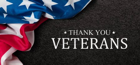 Closeup of American flag with Text Thank You Veterans on black textured background. American holiday banner.