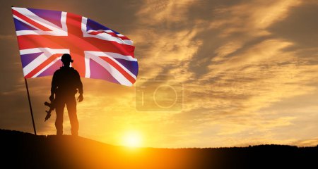 Silhouette eines Soldaten mit britischer Flagge auf dem Hintergrund des Sonnenuntergangs. Grußkarte zum Mohntag, Gedenktag. Feier im Vereinigten Königreich.