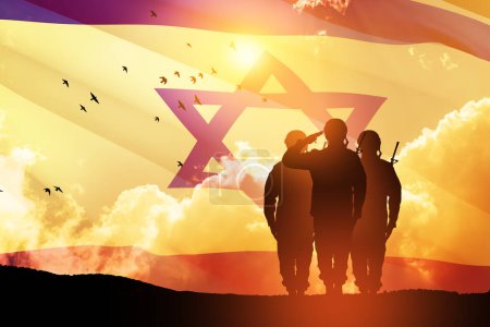 Silhouetten von Soldaten, die gegen den Sonnenaufgang in der Wüste salutieren und die israelische Flagge. Konzept - Streitkräfte Israels.