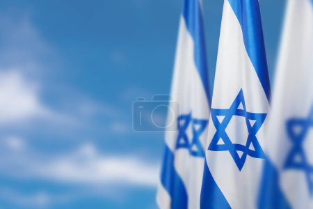 Israel flags with a star of David over cloudy sky background. Patriotic concept about Israel with national state symbols. Banner with place for text.