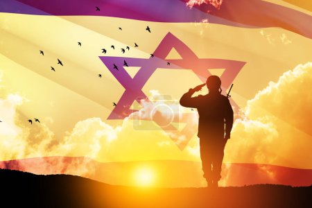 Silueta de soldado saludando contra el amanecer en el desierto y la bandera de Israel. Concepto - Fuerzas Armadas de Israel.