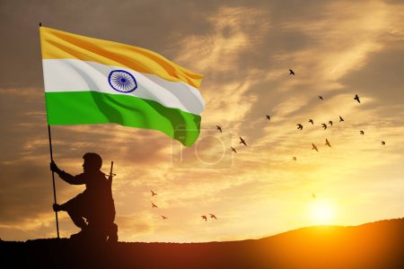 Silhouette eines Soldaten mit Indien-Flagge und fliegenden Vögeln auf einem Hintergrund der Sonnenuntergang oder der Sonnenaufgang. Grußkarte zum Unabhängigkeitstag, Tag der Republik. Indien-Feier.