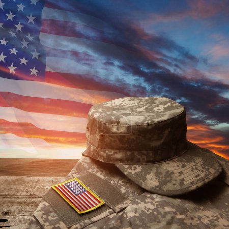 Photo for USA military uniform with insignias on old wooden table on sunset sky background with USA flag. Memorial Day or Veterans day concept. - Royalty Free Image