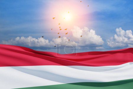 Téléchargez les photos : Waving flag of Hungary in blue sky with flying birds. Independence day, National day. Background with place for your text. 3d-rendering. - en image libre de droit