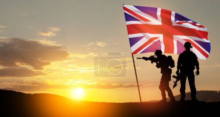 Silhouettes of soldiers with United Kingdom flag on background of sunset. Greeting card for Poppy Day, Remembrance Day. United Kingdom celebration.