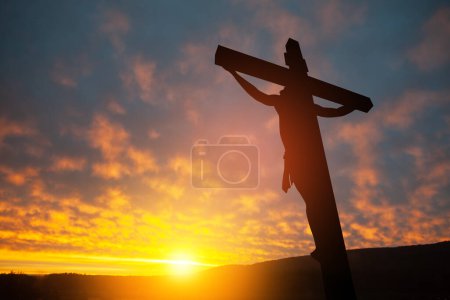 Téléchargez les photos : Silhouette de Jésus Christ crucifié sur la croix sur fond de ciel couchant. - en image libre de droit