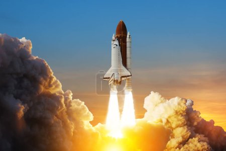 Photo for Spaceship lift off. Space shuttle with smoke and blast takes off into space on a background of sunset. Successful start of a space mission. Elements of this image furnished by NASA. - Royalty Free Image