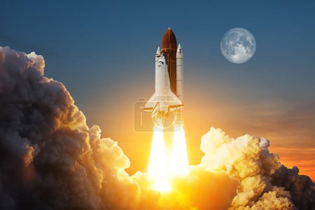 Téléchargez les photos : Spaceship lift off. Space shuttle with smoke and blast takes off into space on a background of a sunset with a full moon in the sky. Elements of this image furnished by NASA. - en image libre de droit