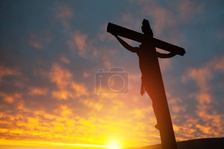 Téléchargez les photos : Silhouette de Jésus Christ crucifié sur la croix sur fond de ciel couchant. - en image libre de droit