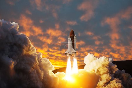 Foto de La nave espacial despega. El transbordador espacial con humo y explosión despega al espacio sobre un fondo de puesta de sol. Inicio exitoso de una misión espacial. Elementos de esta imagen proporcionados por la NASA. - Imagen libre de derechos