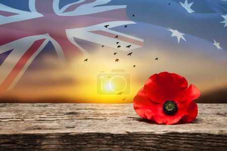 Poppy pin for Anzac Day. Poppy flower on old beautiful high grain, detailed wood on background of sunset sky and transparent Australia flag. Anzac Day Lest We Forget.