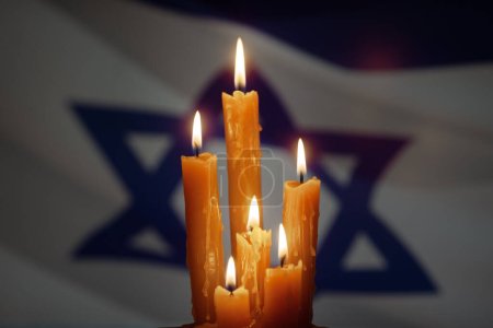 Six burning candles on Israel flag background. Holocaust Remembrance Day.