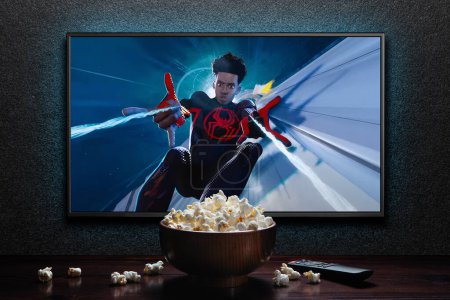 Foto de Pantalla de TV que reproduce Spider-Man a través del tráiler o película de Spider-Verse. TV con control remoto y tazón de palomitas. Astana, Kazajstán - 15 de mayo de 2023. - Imagen libre de derechos