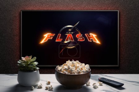 Photo for TV screen playing The Flash trailer or movie. TV with remote control, popcorn bowl and home plant. Astana, Kazakhstan - May 15, 2023. - Royalty Free Image