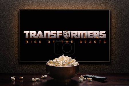 Photo for TV screen playing Transformers Rise of the Beasts trailer or movie. TV with remote control and popcorn bowl. Astana, Kazakhstan - May 15, 2023. - Royalty Free Image