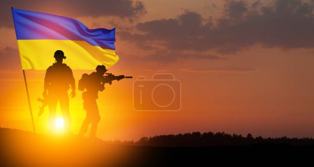 Flag of Ukraine with silhouette of soldiers against the sunrise or sunset. Concept - armed forces of Ukraine. Relationship between Ukraine and Russia.