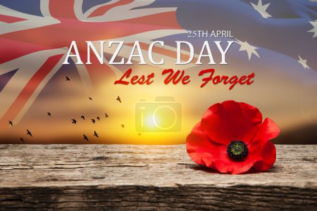 Épinglette de pavot pour la journée Anzac. Fleur de pavot sur vieux beau grain élevé, bois détaillé sur fond de ciel couchant et drapeau d'Australie transparent. Jour d'Anzac De peur que nous oublions.