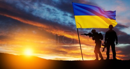 Bandera de Ucrania con silueta de soldado contra el amanecer o la puesta del sol. Concepto - Fuerzas Armadas de Ucrania. Relación entre Ucrania y Rusia.