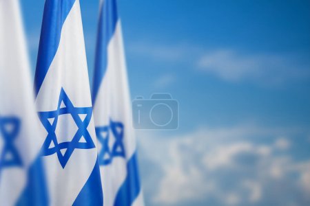 Téléchargez les photos : Israël drapeaux avec une étoile de David sur fond de ciel nuageux sur le coucher du soleil. Concept patriotique sur Israël avec des symboles nationaux de l'État. Bannière avec place pour le texte. - en image libre de droit