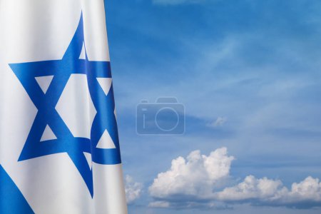 Bandera de Israel con una estrella de David sobre el fondo nublado del cielo. Concepto patriótico sobre Israel con símbolos estatales nacionales. Banner con lugar para texto.
