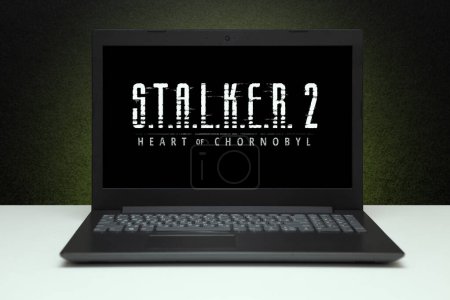 Photo for S.T.A.L.K.E.R. 2 Heart of Chornobyl, Stalker 2 game on the screen laptop computer on black textured wall with green light. Moscow, Russia - March 20, 2023. - Royalty Free Image