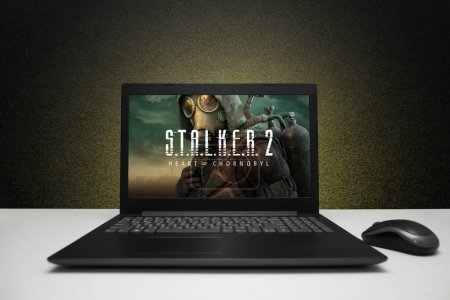 Photo for S.T.A.L.K.E.R. 2 Heart of Chornobyl, Stalker 2 game on the screen laptop computer on black textured wall with yellow light. Moscow, Russia - March 20, 2023. - Royalty Free Image
