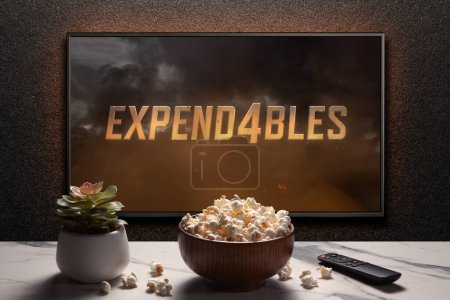 Photo for The expendables 4 trailer or movie on TV screen. TV with remote control, popcorn bowl and home plant. Astana, Kazakhstan - September 8, 2023. - Royalty Free Image