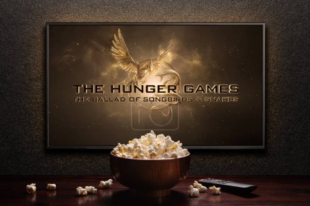 Photo for The Hunger Games The Ballad of Songbirds and Snakes trailer or movie on TV screen. TV with remote control and popcorn bowl. Astana, Kazakhstan - September 8, 2023. - Royalty Free Image