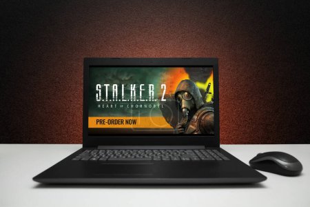 Photo for S.T.A.L.K.E.R. 2 Heart of Chornobyl, Stalker 2 game on the screen laptop computer on black textured wall with red light. Pre-order. Moscow, Russia - March 20, 2023. - Royalty Free Image