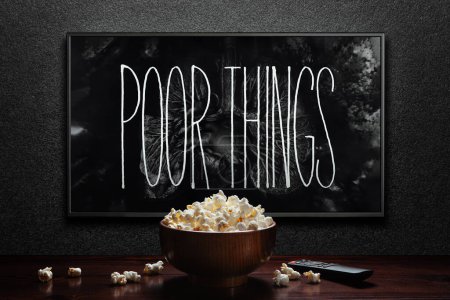 Photo for Poor Things trailer or movie on TV screen. TV with remote control and popcorn bowl. Astana, Kazakhstan - September 8, 2023. - Royalty Free Image