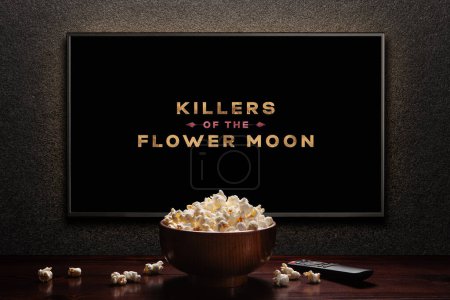 Téléchargez les photos : Killers of the Flower Moon bande-annonce ou film à l'écran de télévision. TV avec télécommande et bol de maïs soufflé. Astana, Kazakhstan - 8 septembre 2023. - en image libre de droit