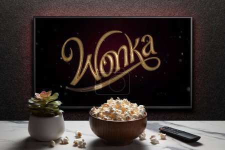 Foto de Wonka trailer o película en la pantalla de TV. TV con control remoto, tazón de palomitas de maíz y planta casera. Astana, Kazajstán - 28 de octubre de 2023. - Imagen libre de derechos