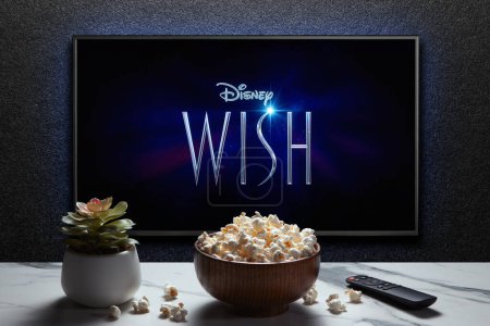 Photo for Wish trailer or movie on TV screen. TV with remote control, popcorn bowl and home plant. Astana, Kazakhstan - November 15, 2023. - Royalty Free Image