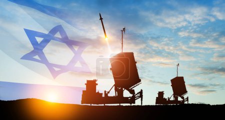 Foto de Lanzamientos de misiles de defensa aérea Iron Dome de Israel. Los misiles apuntan al cielo al atardecer con la bandera de Israel. Defensa de misiles, un sistema de fuego de salva. - Imagen libre de derechos