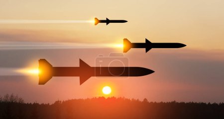 Photo for Fired missiles fly to the target. Missiles at the sky at sunset. Missile defense, a system of salvo fire. - Royalty Free Image