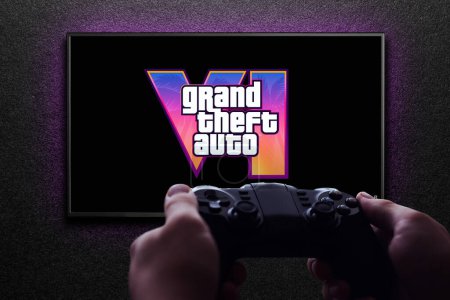 Photo for Grand Theft Auto 6 trailer game on TV screen with gamepad in hand on black textured wall with light. Astana, Kazakhstan - December 5, 2023. - Royalty Free Image