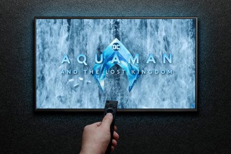 Photo for Aquaman and the Lost Kingdom trailer or movie on TV screen. Man turns on TV with remote control. Astana, Kazakhstan - December 5, 2023. - Royalty Free Image