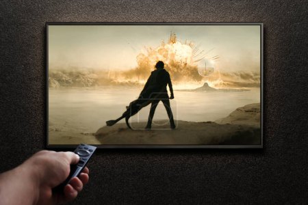 Foto de Pantalla de TV jugando Dune Parte Dos trailer o película. El hombre enciende la televisión con control remoto. Astana, Kazajstán - 15 de mayo de 2023. - Imagen libre de derechos