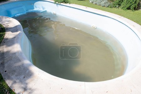Schmutziges Schwimmbad zum Saisonstart mit braunem Schlammwasser