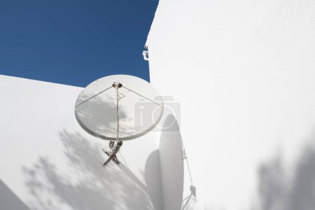 Satellitenschüssel an der Wand eines weißen Hauses